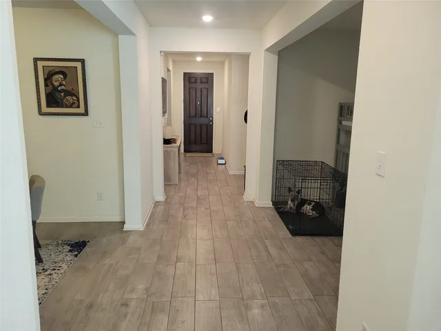 a view of a livingroom with wooden floor and a bathroom