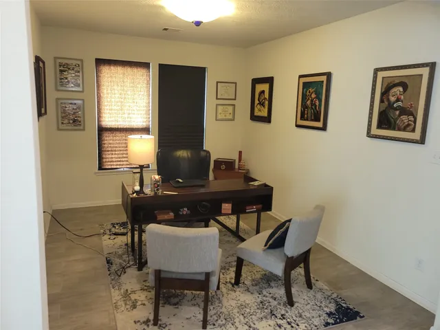 a view of a workspace with furniture and window