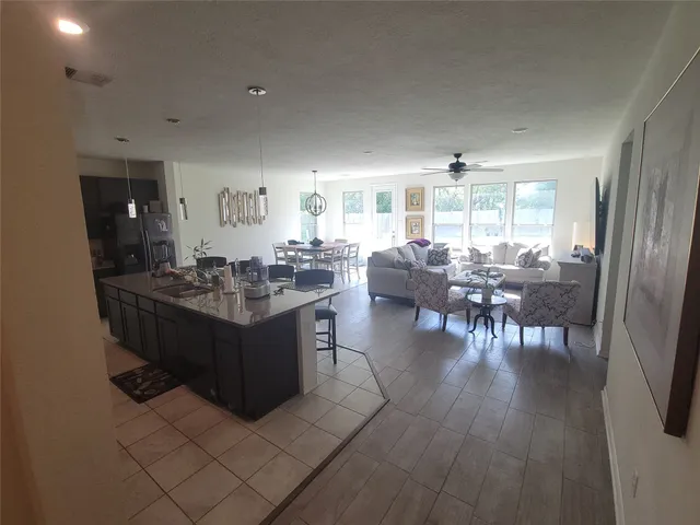 a living room with furniture a large window and wooden floor