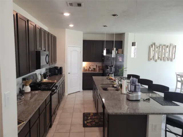 a kitchen with a refrigerator and a stove top oven