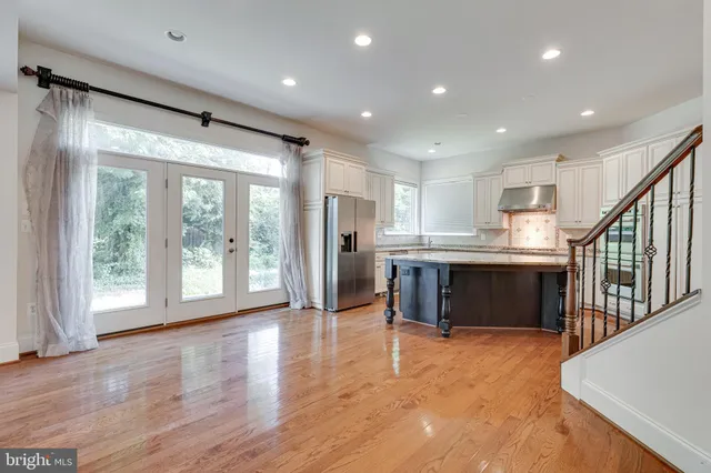 a view of a furniture and an empty room with wooden floor and a window