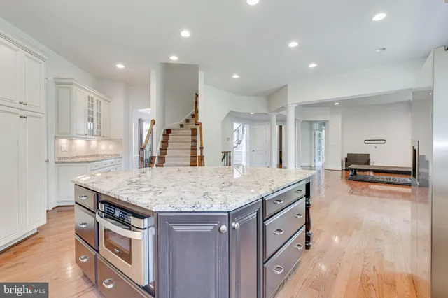 a kitchen with stainless steel appliances granite countertop a kitchen island a stove and a sink