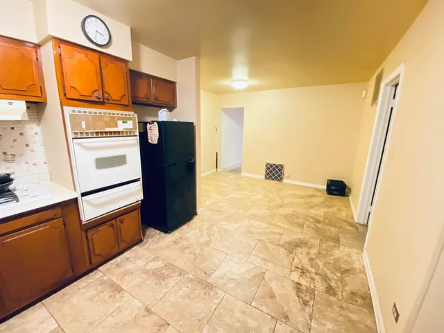 a view of a refrigerator in kitchen and a stove