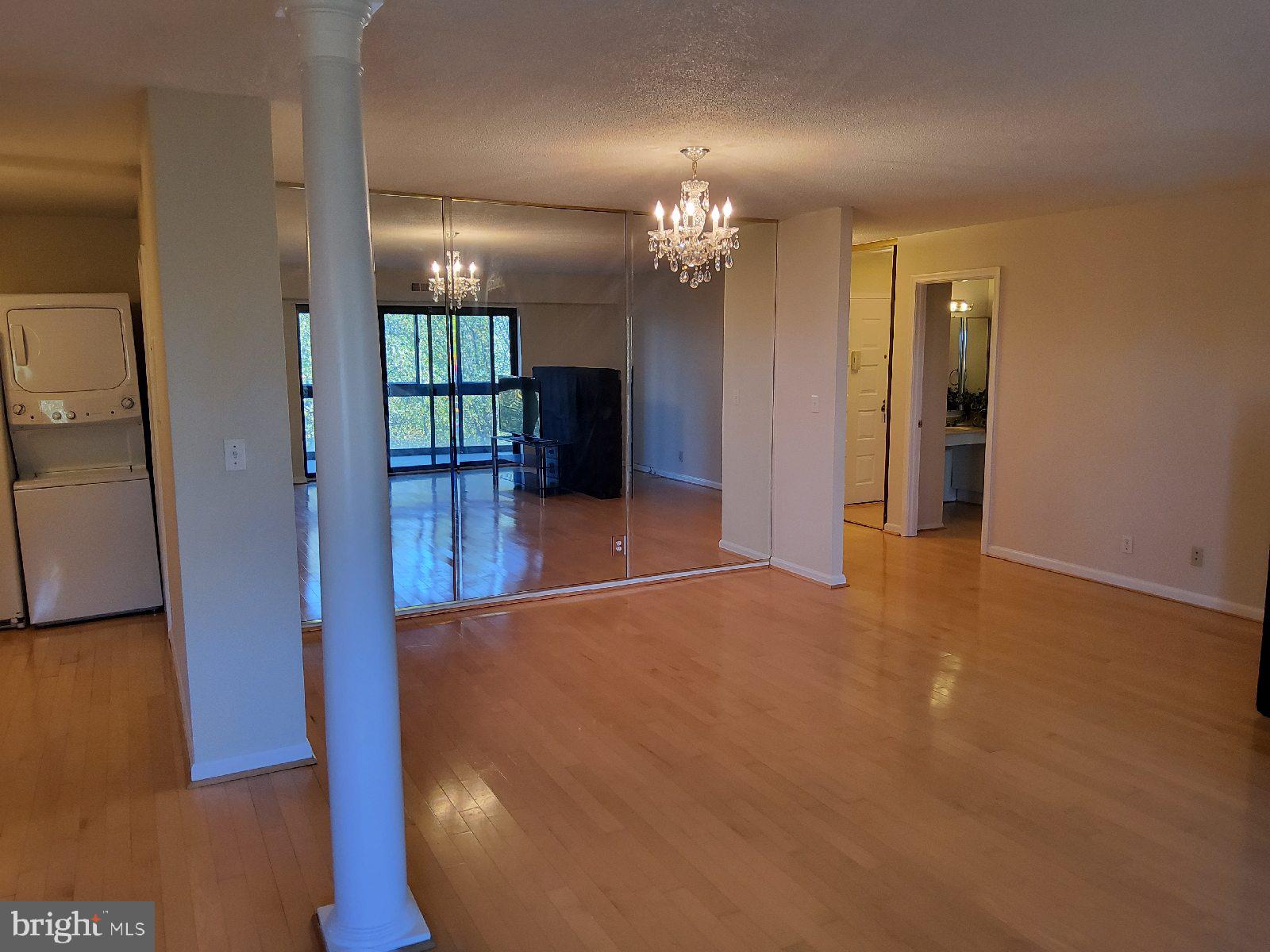 8370 Greensboro Drive, Unit 806 McLean, VA 22102 - Photo 11 of 31 an empty room with chandelier fan and windows