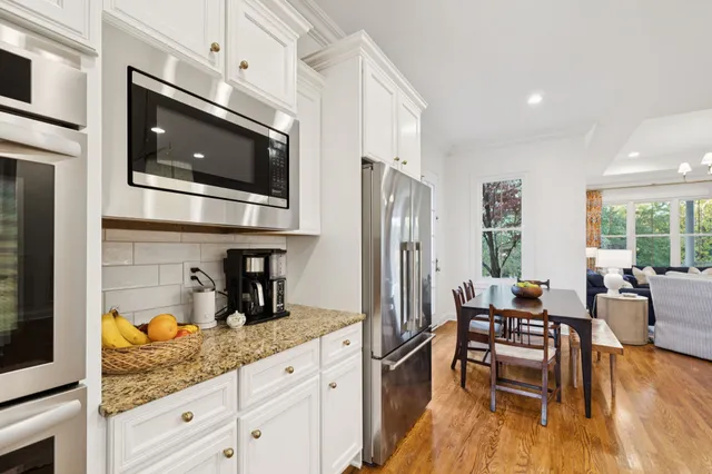 a kitchen with granite countertop stainless steel appliances a sink stove and cabinets