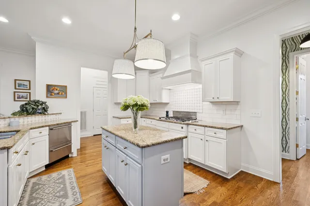 a kitchen with stainless steel appliances granite countertop a stove refrigerator and a view of living room