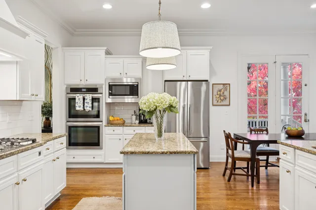 a kitchen with a dining table chairs and view of living room