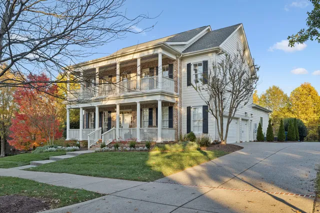 a front view of a house with a yard and trees