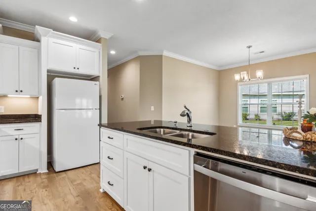 a kitchen with stainless steel appliances granite countertop a refrigerator and a sink