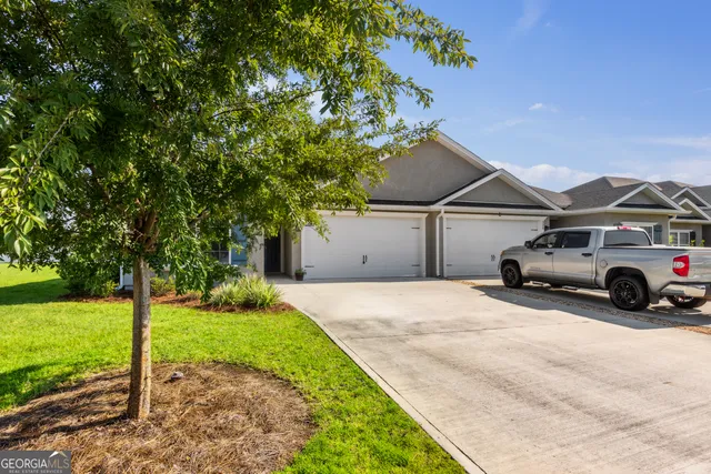 a view of a car in front of a house with a yard