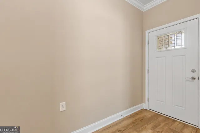 a view of a small space with wooden floor and a window