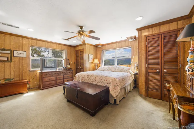 a spacious bedroom with a bed and wooden floor