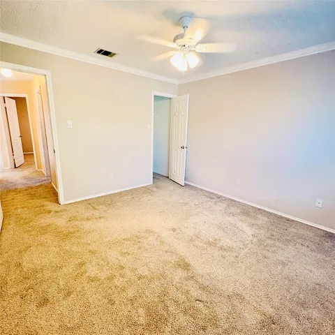 an empty room with a chandelier fan and windows