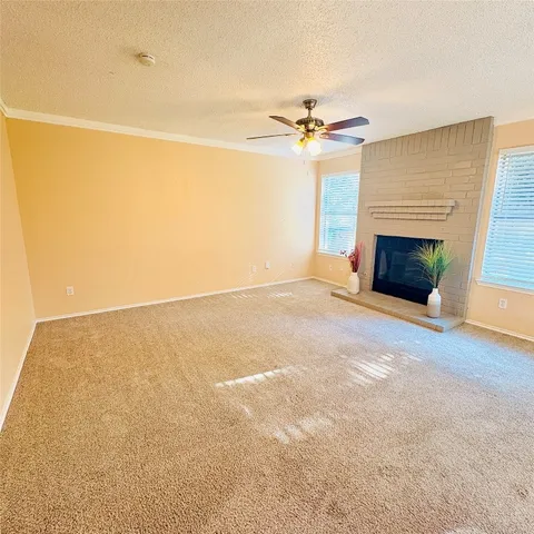 en empty room with windows and fireplace