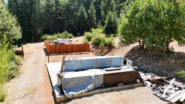 a view of a patio with table and chairs potted plants with large tree