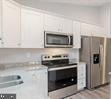 Plum Tree Lane Berkeley Springs, WV 25411 - Photo 4 of 18 a kitchen with granite countertop a stove and a microwave