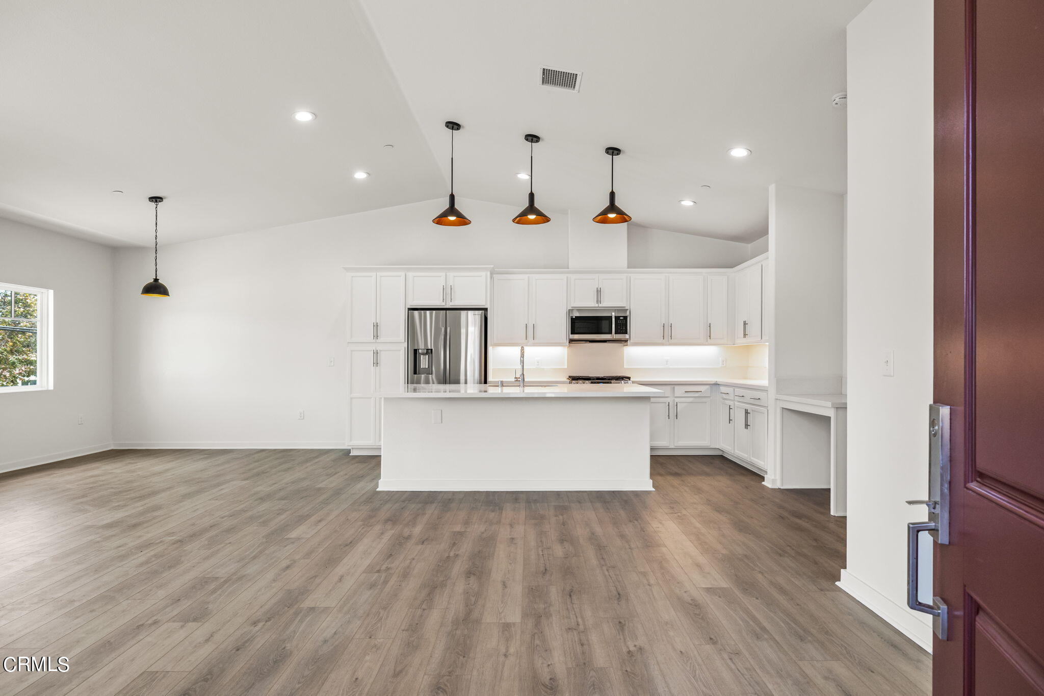 311 North F Street, Unit 202 Oxnard, CA 93030 - Photo 1 of 32 a large white kitchen with a large window a counter space and stainless steel appliances