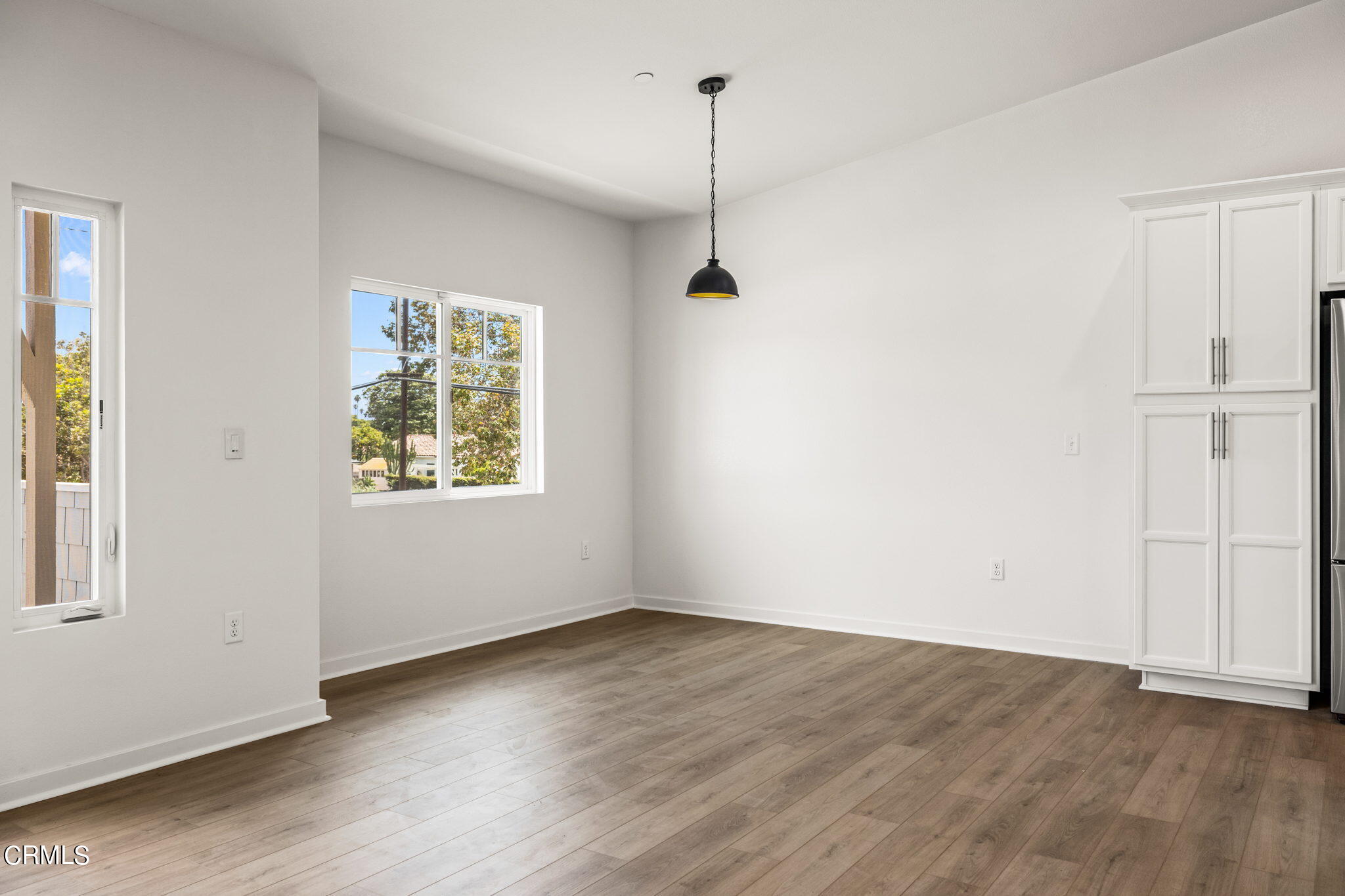 311 North F Street, Unit 202 Oxnard, CA 93030 - Photo 13 of 32 an empty room with wooden floor cabinet and windows