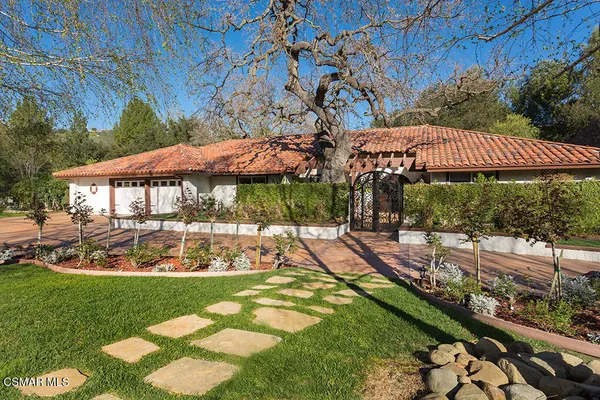 a view of a house with a yard table and chairs under an umbrella