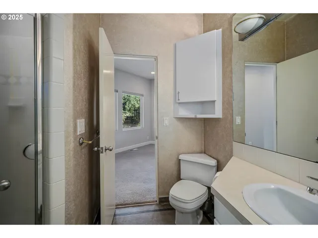 a bathroom with a toilet sink a shower and vanity