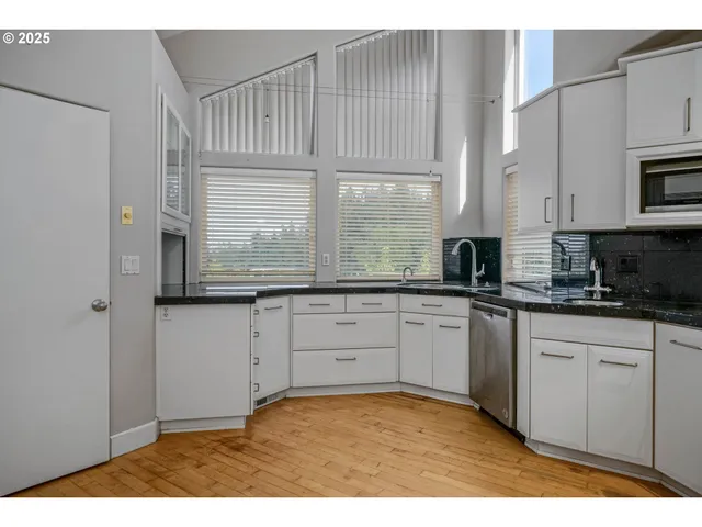 a kitchen with granite countertop white cabinets and white appliances