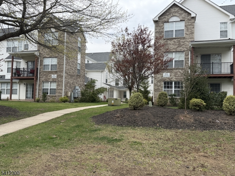 920 Plymouth Road North Brunswick, NJ 08902 - Photo 3 of 17 a view of a brick house next to a yard with big trees