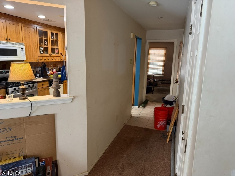 920 Plymouth Road North Brunswick, NJ 08902 - Photo 6 of 17 a hallway with a couch and a stove next to a window