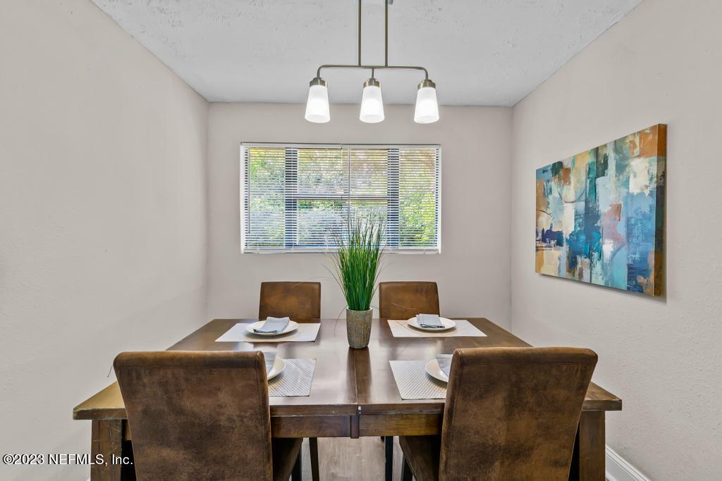 2142 Benedict Road Jacksonville, FL 32209 - Photo 12 of 34 a view of a dining room with furniture a chandelier and a window