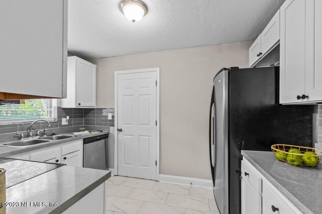 2142 Benedict Road Jacksonville, FL 32209 - Photo 13 of 34 a kitchen with stainless steel appliances granite countertop a refrigerator a stove a sink a counter space and cabinets