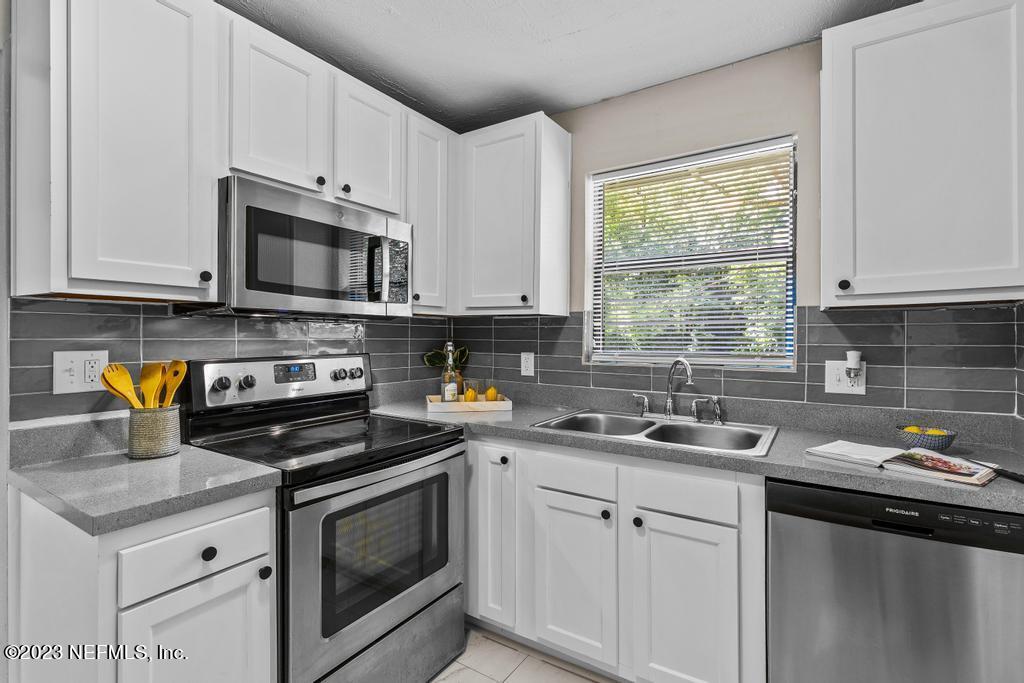 2142 Benedict Road Jacksonville, FL 32209 - Photo 17 of 34 a kitchen with a sink stove top oven and microwave