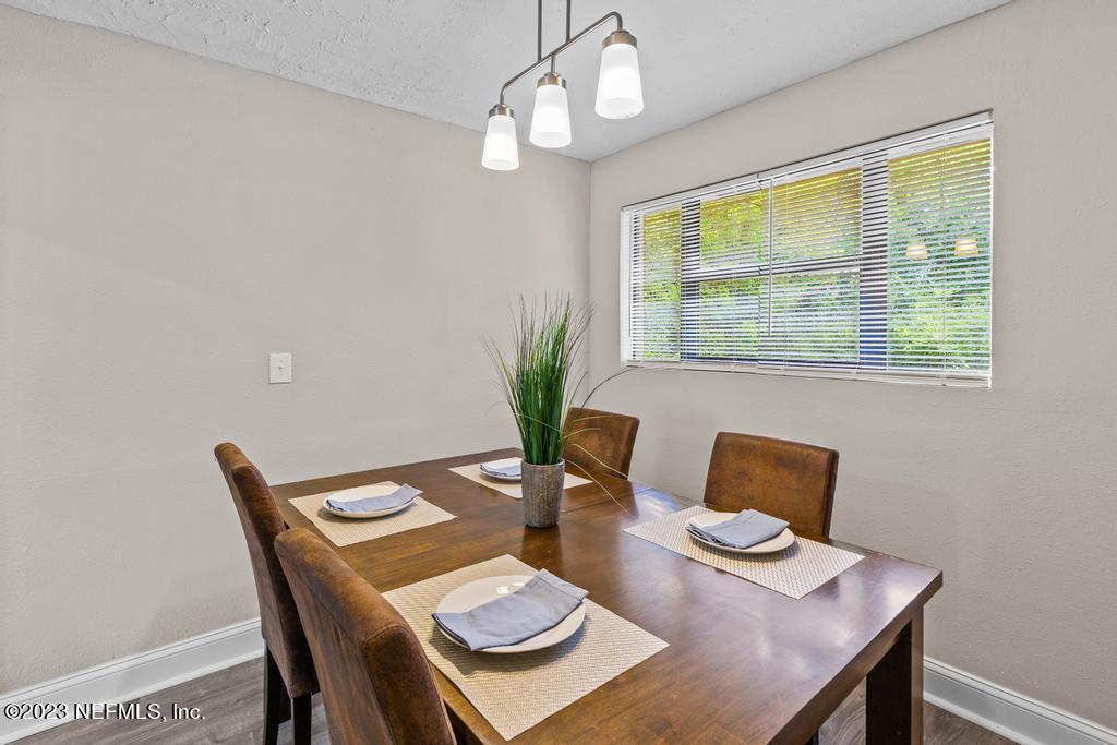 2142 Benedict Road Jacksonville, FL 32209 - Photo 19 of 34 a view of a dining room with furniture a chandelier and wooden floor