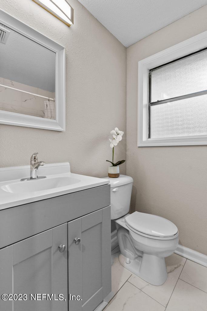 2142 Benedict Road Jacksonville, FL 32209 - Photo 21 of 34 a bathroom with a toilet sink and mirror