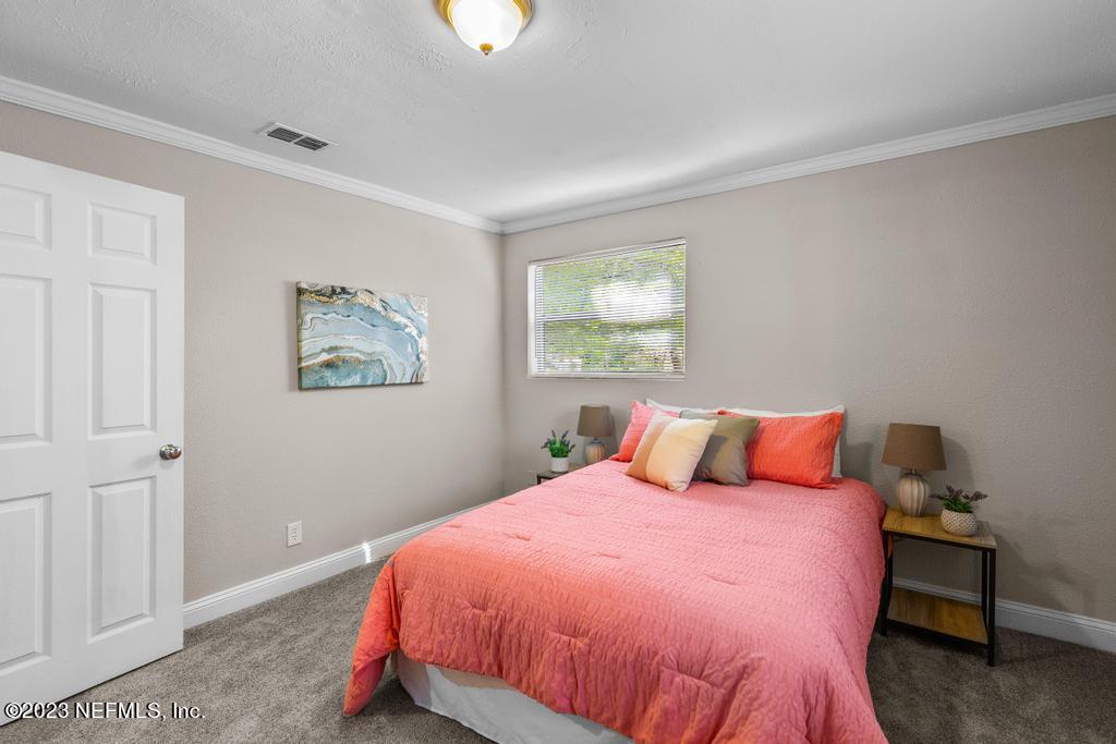 2142 Benedict Road Jacksonville, FL 32209 - Photo 30 of 34 a bedroom with a bed and painting on the wall