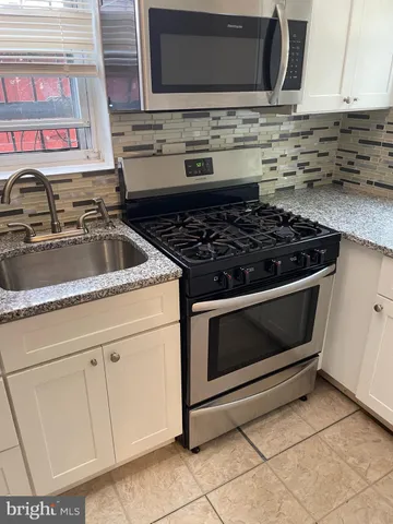 a stove top oven sitting inside of a kitchen