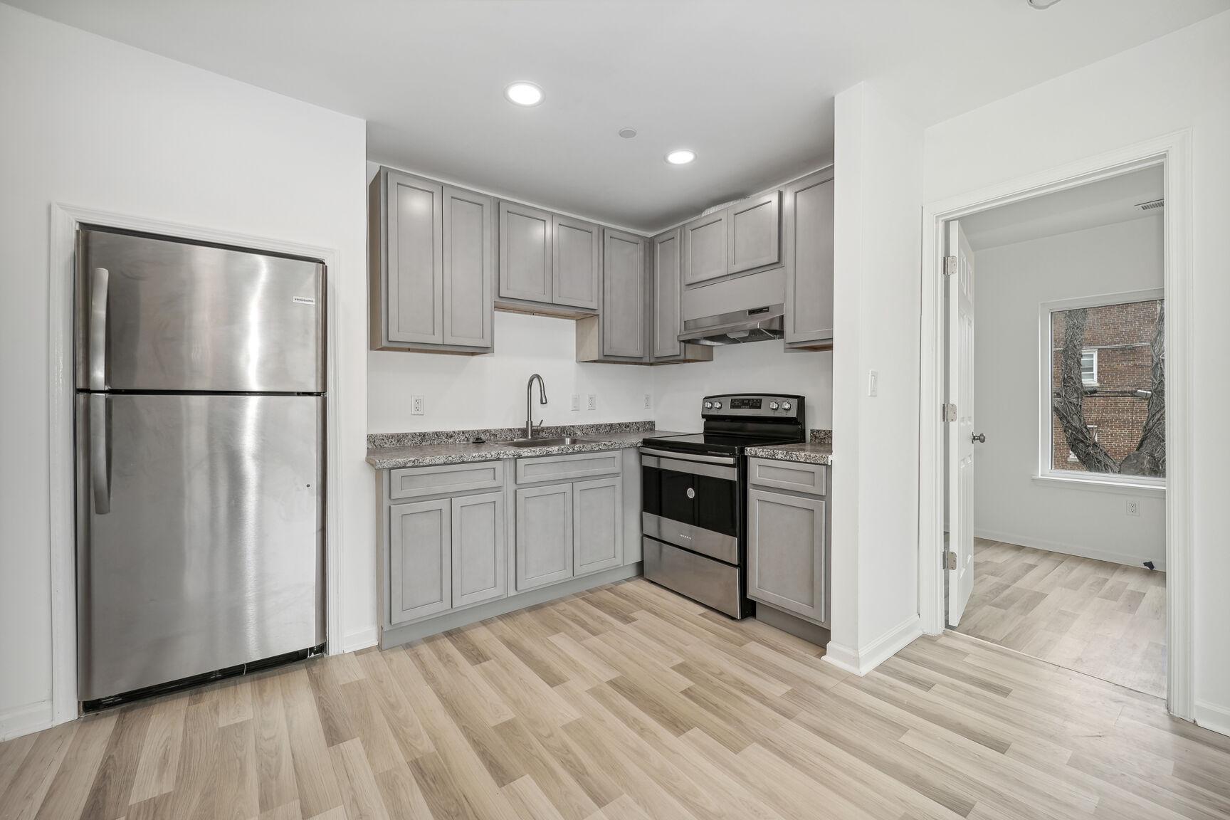 1642 16th Street Southeast, Unit 3 Washington, DC 20020 - Photo 10 of 22 a kitchen with a refrigerator a stove top oven and white cabinets