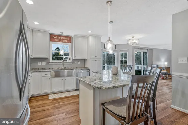 a kitchen with stainless steel appliances granite countertop a kitchen island a stove a table and chairs in it