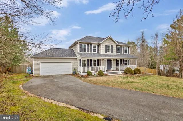 a front view of a house with a yard and trees