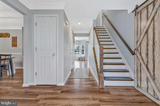 a view of entryway and hall with wooden floor