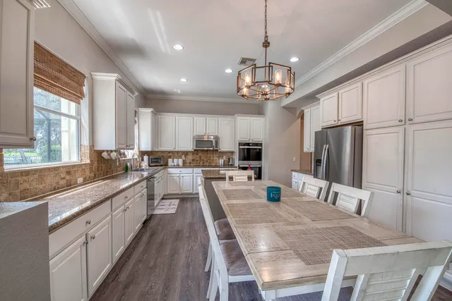 a large kitchen with kitchen island a large island a sink stainless steel appliances and windows