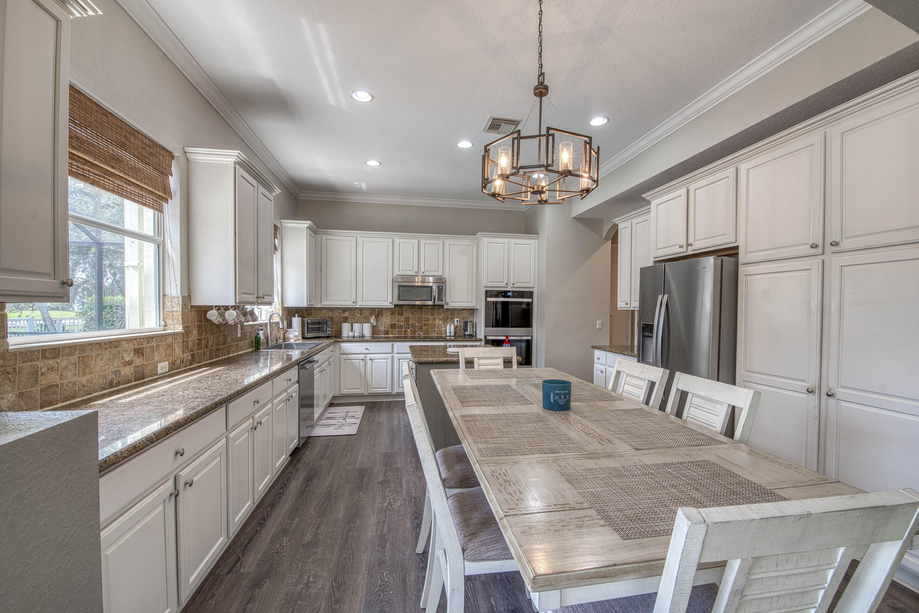410 Cresta Circle West Palm Beach, FL 33413 - Photo 14 of 46 a large kitchen with kitchen island a large island a sink stainless steel appliances and windows