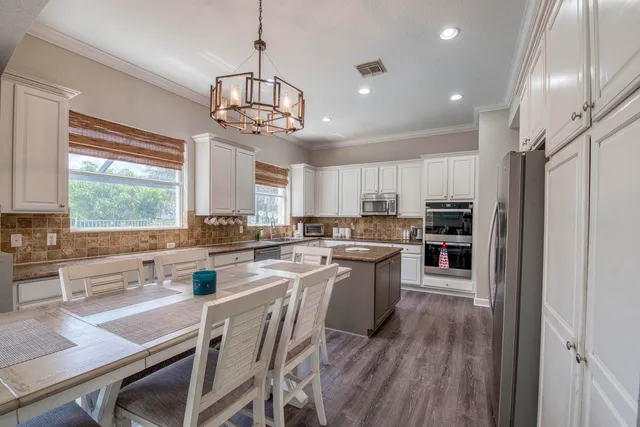 a kitchen with refrigerator a stove and wooden floor