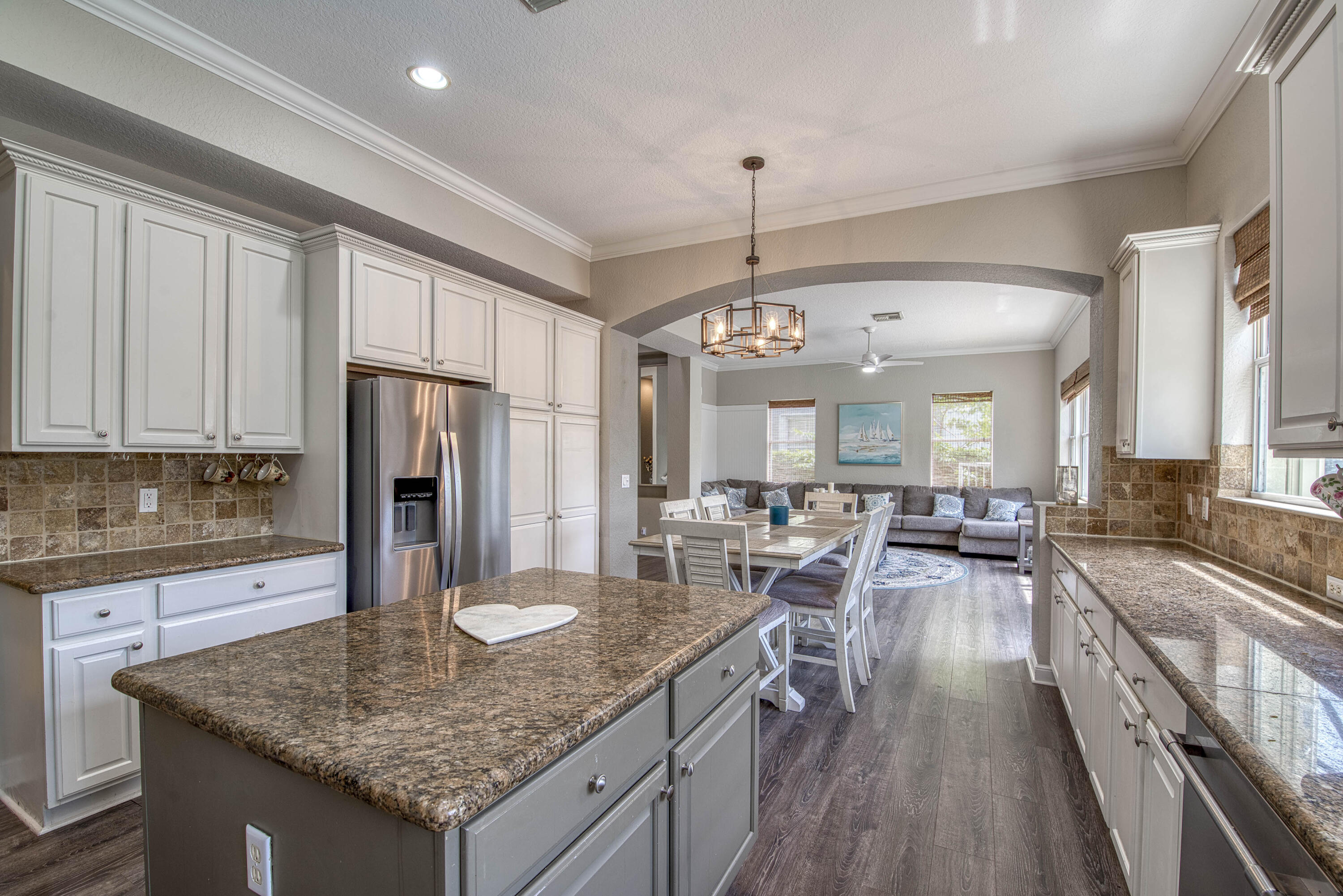 410 Cresta Circle West Palm Beach, FL 33413 - Photo 17 of 46 a kitchen with stainless steel appliances granite countertop a kitchen island a stove a refrigerator a sink dishwasher a dining table and chairs with wooden floor