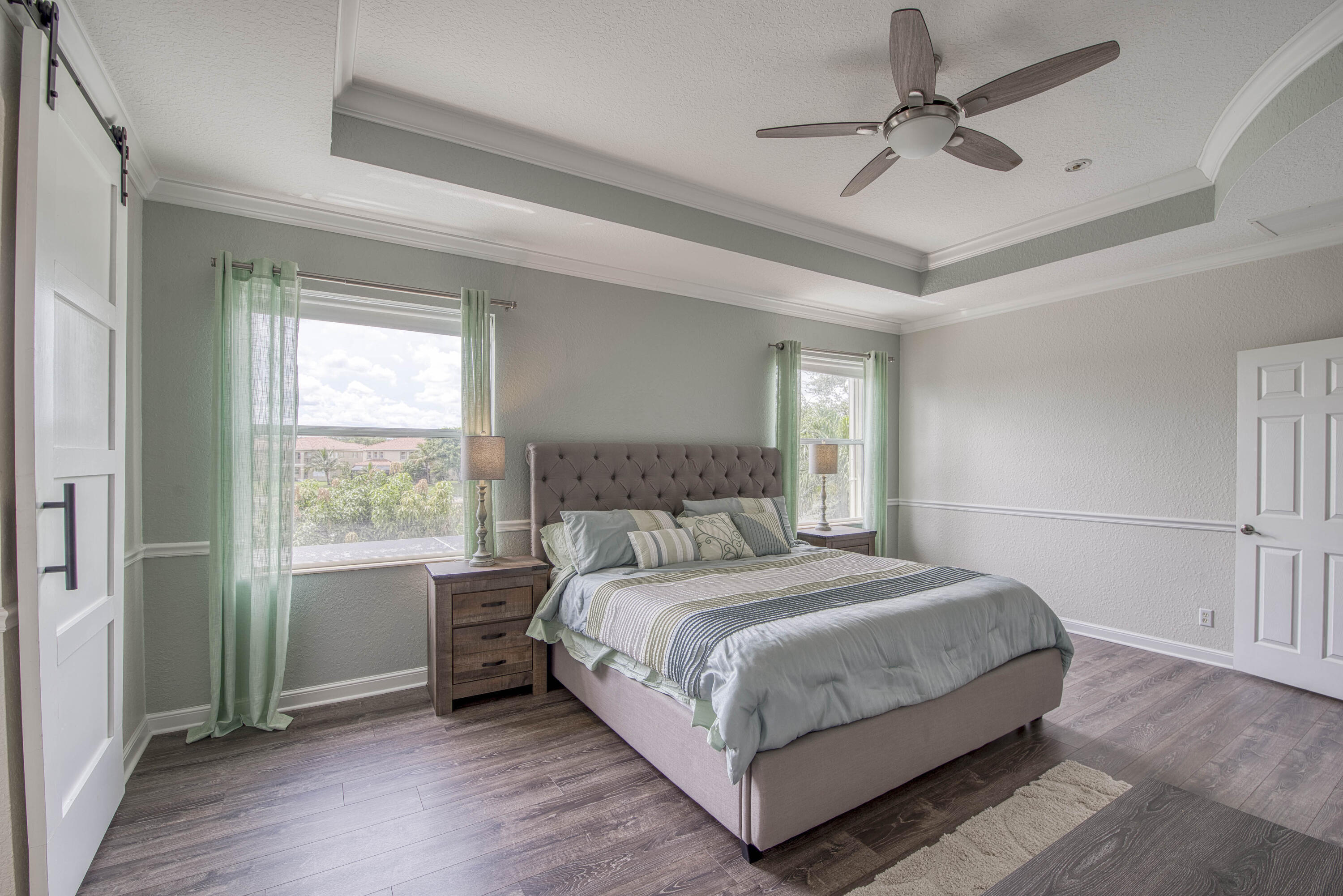 410 Cresta Circle West Palm Beach, FL 33413 - Photo 23 of 46 a bedroom with a large bed chandelier and a window