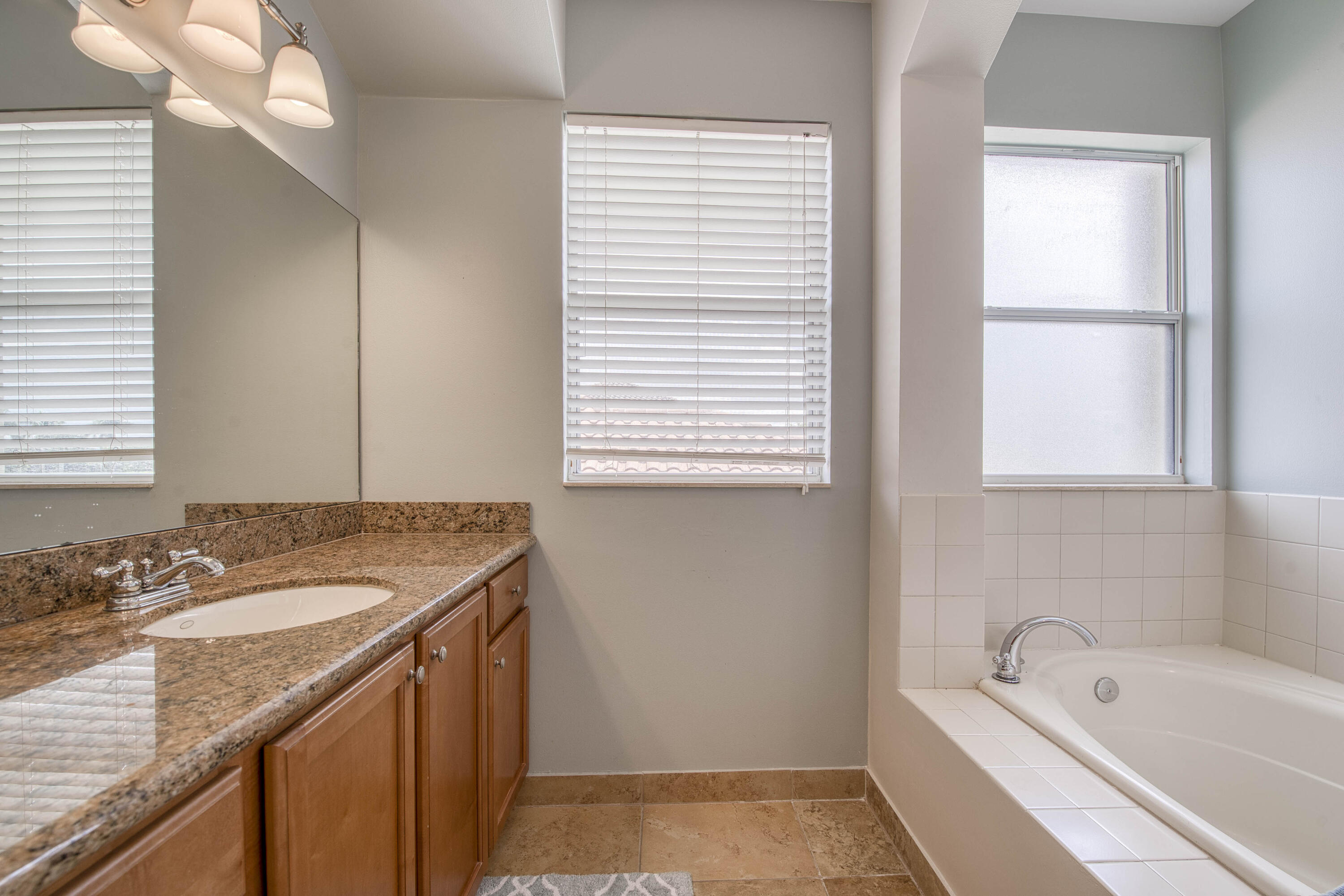 410 Cresta Circle West Palm Beach, FL 33413 - Photo 27 of 46 a bathroom with a granite countertop sink and a bathtub
