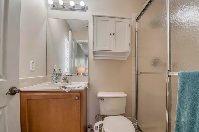 a bathroom with a granite countertop sink toilet and shower