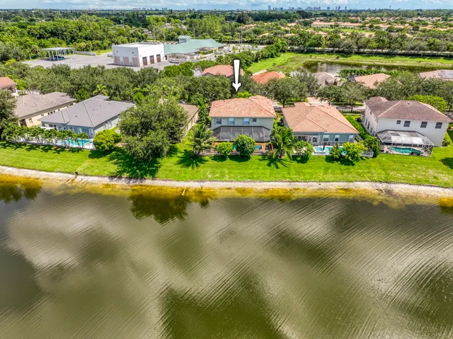 an aerial view of a house with a lake view and a yard