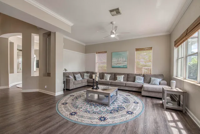 a living room with furniture and a wooden floor