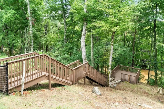 a view of a wooden deck with a bench and trees
