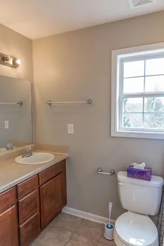 a bathroom with a toilet sink and mirror