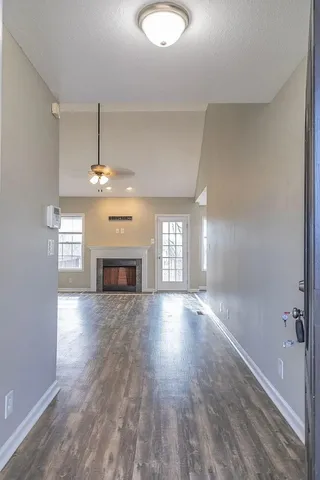 a view of empty room with wooden floor and fireplace